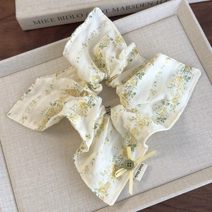 Detail of floral scrunchie with yellow bow, green button, and handmade label