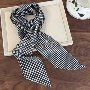 Detail of black and white checkerboard silk scarf with floral pattern on a tray