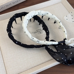 Close-up of polka dot headbands with non-slip inner teeth and chiffon ribbon detail