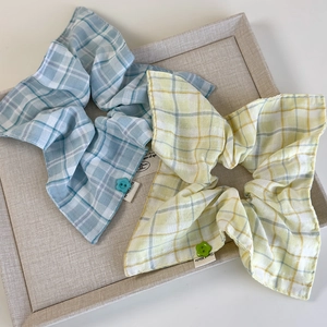 Close-up of mint yellow and light blue plaid hair scrunchies with button detail