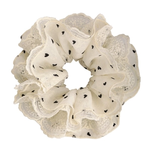 Close-up of cream heart-print scrunchie with layered lace edges and soft chiffon texture