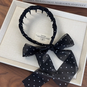 Polka dot headband with large bow tassel and inner teeth for secure hair styling