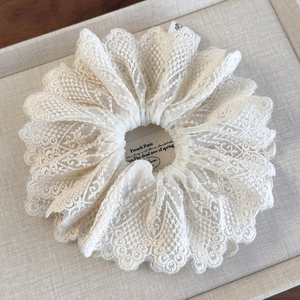 Détail du chouchou en dentelle beige avec broderie florale et style français élégant