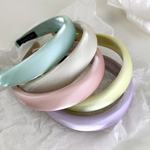 Stack of thick sponge padded silk satin headbands in pastel macaron colors with handmade label