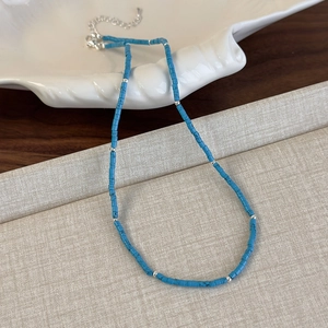 Détail du collier de perles turquoise bleues avec fermoir mousqueton argenté et chaîne