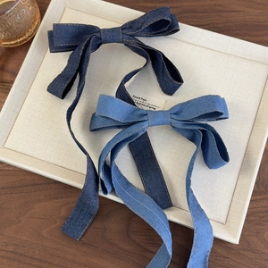 Denim bow hair clip with long ribbons in dark and light blue with yellow stitching