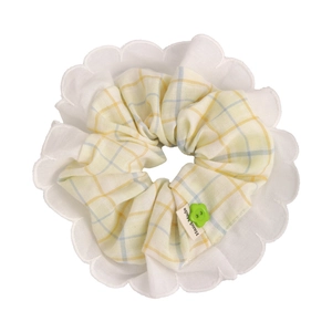 Pastel plaid scrunchie with white lace edges and a green flower button detail