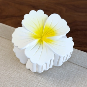 Close-up of matte gradient plumeria hair claw clip with realistic flower petal textures