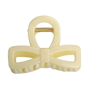 Détail d'une pince à cheveux crème en forme de nœud avec ressort en métal doré robuste