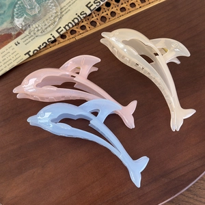 Three elegant dolphin-shaped hair claws in pink, blue, and cream pearlescent acrylic