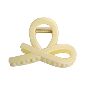 Détail d'une pince à cheveux en acrylique crème avec ressort métallique doré brillant