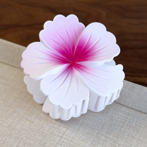 Macro detail of a matte gradient hibiscus hair claw clip with floral design