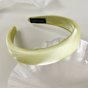 Macro detail of high-quality satin padded headband with handmade label on shell tray
