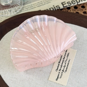 Detailed view of pearlescent pink seashell hair claw clip with strong metal spring