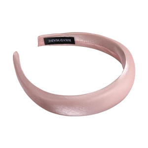 Elegant light pink pearl satin padded headband with a wide brim and handmade label tag