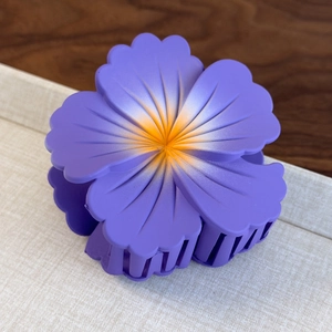 Detail view of purple frosted gradient flower claw clip with textured petals for hair styling