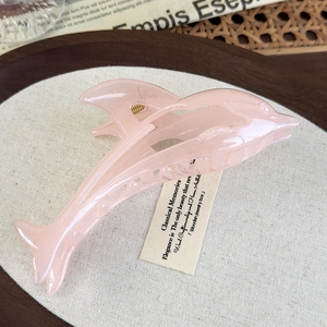 Detail of pink jelly dolphin hair claw clip with shimmer finish for elegant styling
