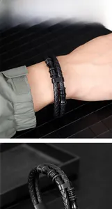 Detail of a double-layered black woven leather bracelet with matte metal magnetic clasp
