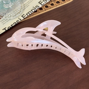 Detailed view of pink glitter dolphin hair claw clip with golden metal spring