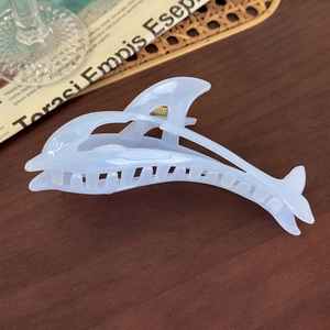 Detailed view of light blue dolphin hair claw clip with acetate finish and metallic spring
