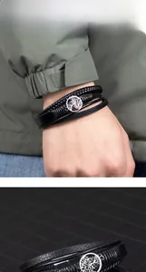 Close-up of men's multi-layer black braided leather bracelet with Tree of Life charm