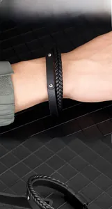 Détail du bracelet double couche en cuir noir tressé avec des rivets métalliques