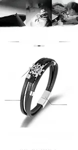 Detail eines geflochtenen Lederarmbands mit Steuerrad-Anhänger und Magnetverschluss, 21cm