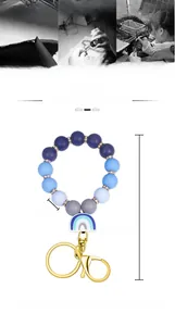Detail of blue gradient silicone bead keychain with rainbow charm and gold metal clasp