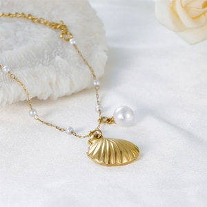 Collier élégant en forme de coquillage doré avec perles blanches sur fond de soie douce