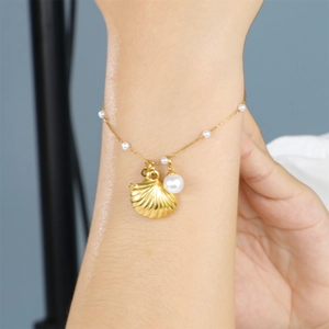 Bracelet coquillage et perles plaqué or pour femme avec un design bijoux de plage épuré