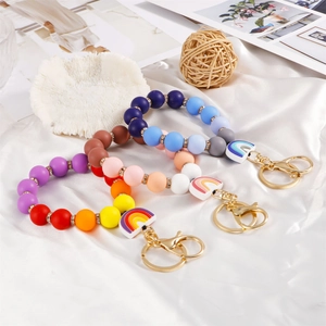 Rainbow silicone bead keychain wristlet with gold spring clasp on white satin