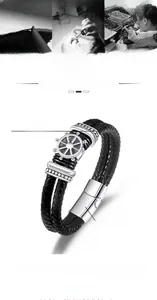 Detail of nautical braided leather bracelet with stainless steel rudder charm and magnetic clasp