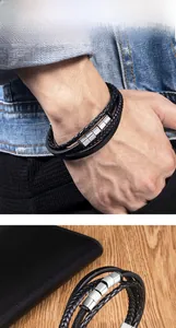 Détail d'un bracelet multicouche en cuir tressé noir pour homme avec fermoir magnétique