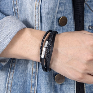 Bracelet pour homme en cuir PU tressé noir avec perles en métal argenté sur jean bleu