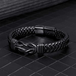Men's black braided leather bracelet featuring a metal infinity knot and magnetic clasp