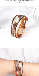 Detail of multilayer leather bracelet with raw crystal, white pearls, and gold magnetic clasp