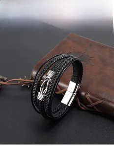 Detail of men's multi-layer black leather bracelet with silver horseshoe buckle and magnetic clasp