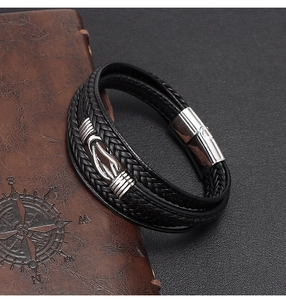 Macro detail of multi-layer braided leather bracelet with silver buckle and infinity knot