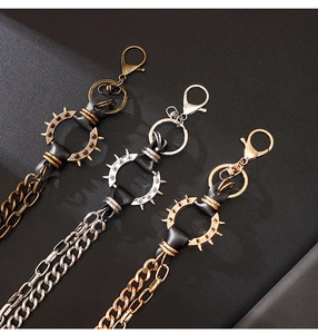 Détail de chaînes de portefeuille punk en bronze argent et or avec anneaux en cuir clouté