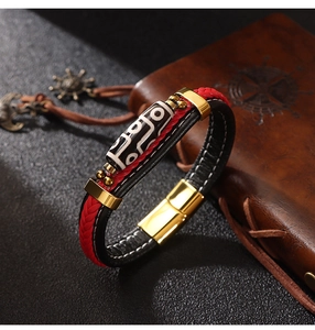 Detail of hand-woven leather bracelet featuring Dzi bead and golden magnetic clasp