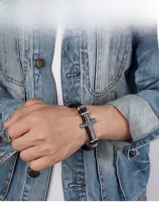 Dettaglio del bracciale da uomo in pelle nera intrecciata con ciondolo a croce d'argento