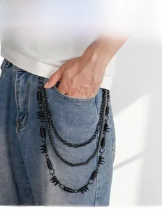 Détail d'une chaîne de pantalon punk noire à trois couches avec pointes sur jean