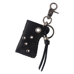Detail of vintage black leather lighter case keychain with metal rings and tassel