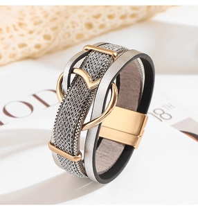 Détail du bracelet en cuir tissé multicouche avec breloques cœur et fermoir magnétique
