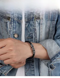 Dettaglio del bracciale in pelle intrecciata con ciondoli totem vichinghi in argento vintage