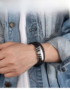 Close-up of men's multi-layer braided black leather bracelet with silver metal charms