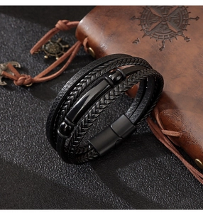 Detailed macro view of multi-layer black leather bracelet with magnetic metal clasp