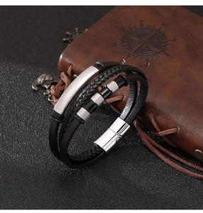 Détail du bracelet en cuir noir tressé avec perles métalliques et fermoir magnétique