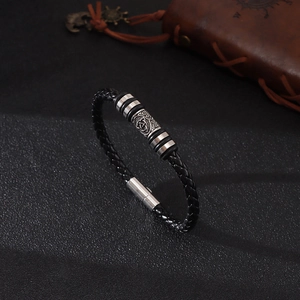 Bracciale in pelle nera intrecciata con perla totem vichingo su sfondo scuro