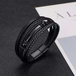 Multi-layer black braided leather bracelet for men with magnetic metal clasp on dark background